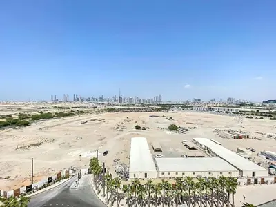 a large parking lot with a city in the background at Mag Eye 910 - Tranquil Studio Apartment in Meydan in Dubai