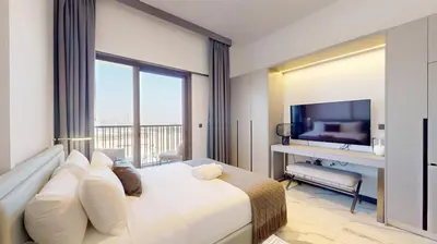 a hotel room with a bed and a television at Mag Eye 910 - Tranquil Studio Apartment in Meydan in Dubai