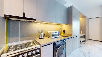a kitchen with a stove and a microwave at Mag Eye 910 - Bright Studio Apartment in Meydan in Dubai