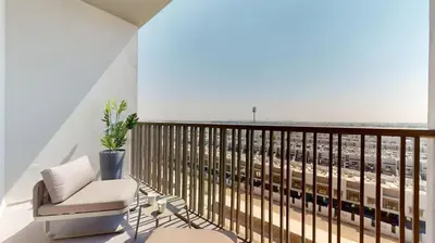 a balcony with a chair and a view of the city at Mag Eye 910 - Bright Studio Apartment in Meydan in Dubai
