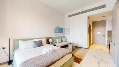 a white bedroom with a bed and a couch at Mag Eye 910 - Bright Studio Apartment in Meydan in Dubai