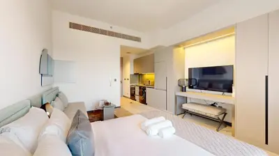 a living room with a white couch and a television at Mag Eye 910 - Bright Studio Apartment in Meydan in Dubai