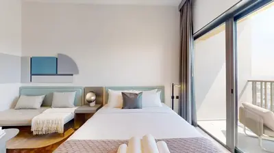 a bedroom with a large bed and a couch at Mag Eye 910 - Aesthetic Studio Apartment in Meydan in Dubai