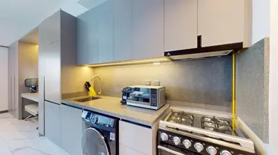 a kitchen with a stove top oven and a microwave at Mag Eye 910 - Aesthetic Studio Apartment in Meydan in Dubai