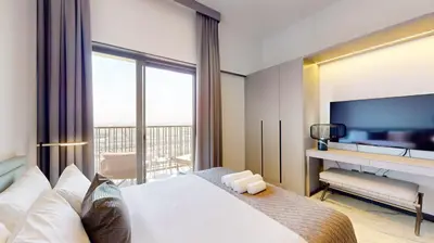 a hotel room with a bed and a television at Mag Eye 910 - Aesthetic Studio Apartment in Meydan in Dubai