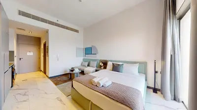 a bedroom with a large bed and a couch at Mag Eye 910 - Aesthetic Studio Apartment in Meydan in Dubai