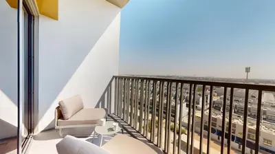 a balcony with a chair and a view of a city at Mag Eye 920 - Classy Studio Apartment in Meydan in Dubai