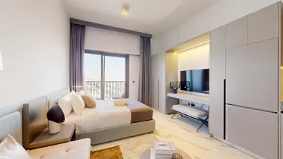 a hotel room with a bed and a desk at Mag Eye 890 - Modern Studio Apartment in Meydan in Dubai