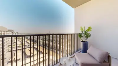 a balcony with a chair and a view of a train at Mag Eye 890 - Modern Studio Apartment in Meydan in Dubai
