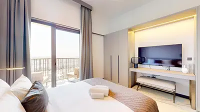 a hotel room with a bed and a television at Vacationer I Stylish Studio I Skyline & Community Views I 12 Mins to Downtown I MAG Eye 910 in Dubai