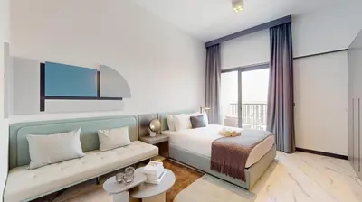 a hotel room with a bed and a couch at Vacationer I Stylish Studio I Skyline & Community Views I 12 Mins to Downtown I MAG Eye 910 in Dubai