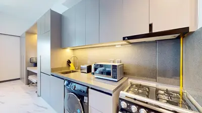 a kitchen with a washing machine and a microwave at Mag Eye 910 - Peaceful Studio Apartment in Meydan in Dubai
