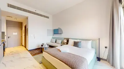 a white bedroom with a bed and a couch at Mag Eye 910 - Peaceful Studio Apartment in Meydan in Dubai