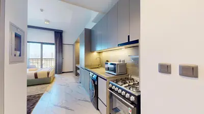 a kitchen with a stove and a microwave at Mag Eye 930 - Calm Studio Apartment in Meydan in Dubai