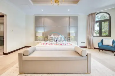 a large bedroom with a large bed and a blue chair at Prestigious 5BR Villa with Assistant Room and Private Pool in Frond O Palm Jumeirah by Deluxe Holiday Homes in Dubai