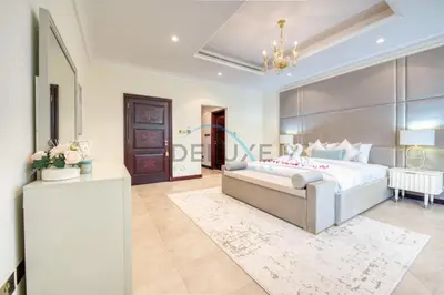a bedroom with a large bed and a table at Prestigious 5BR Villa with Assistant Room and Private Pool in Frond O Palm Jumeirah by Deluxe Holiday Homes in Dubai