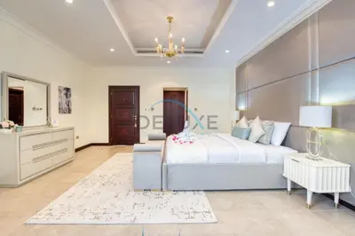 a bedroom with a large bed and a dresser at Prestigious 5BR Villa with Assistant Room and Private Pool in Frond O Palm Jumeirah by Deluxe Holiday Homes in Dubai
