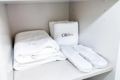 a closet with white towels on a shelf at Citihome - 1BR with Huge Balcony & Easy Transport Access in Dubai
