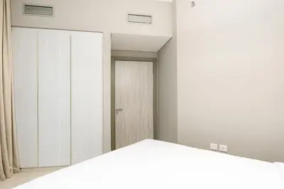 a bedroom with white cabinets and a closet at Citihome - 1BR with Huge Balcony & Easy Transport Access in Dubai