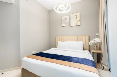 a bedroom with a bed with a blue and white blanket at Citihome - 1BR with Huge Balcony & Easy Transport Access in Dubai