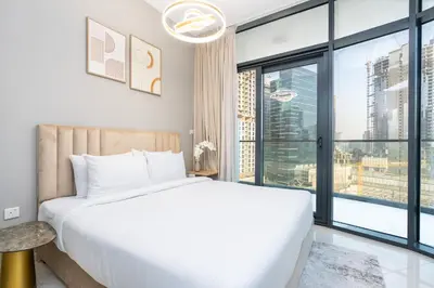 a bedroom with a large bed and a large window at Citihome - 1BR with Huge Balcony & Easy Transport Access in Dubai