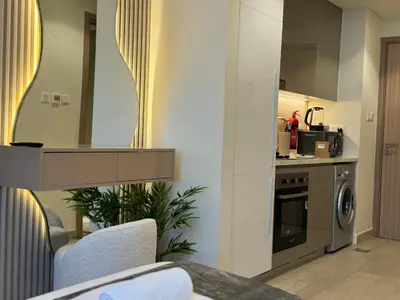 a living room with a kitchen with a sink and a stove at Ashri Elegant Studio Near Burj Khalifa in Dubai