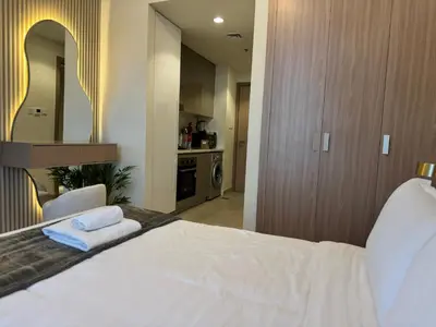 a bedroom with a white bed and a mirror at Ashri Elegant Studio Near Burj Khalifa in Dubai