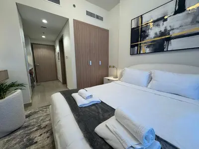 a bedroom with a large white bed with towels on it at Ashri Elegant Studio Near Burj Khalifa in Dubai