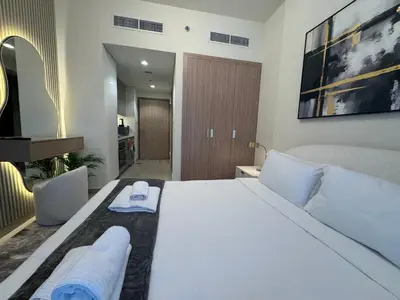 a bedroom with a large white bed with towels on it at Ashri Elegant Studio Near Burj Khalifa in Dubai