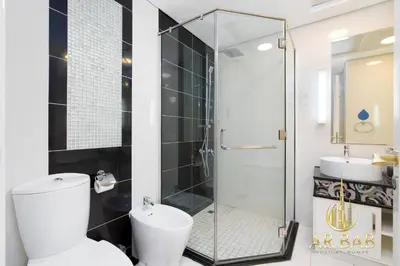 a bathroom with a shower and a toilet and a sink at Damac Maison Mall Street - Royal 3BR - Burj Khalifa View - Near Dubai Mall in Dubai