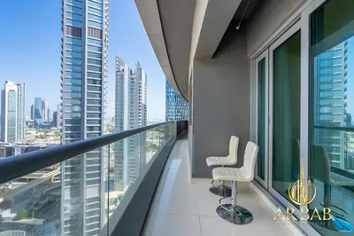 a balcony in a high rise building with two chairs at Damac Maison Mall Street - Royal 3BR - Burj Khalifa View - Near Dubai Mall in Dubai