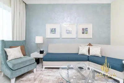 a living room with a couch and a chair at Damac Maison Mall Street - Royal 3BR - Burj Khalifa View - Near Dubai Mall in Dubai