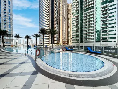 a large swimming pool in a city with tall buildings at Cozy Home at the Heart of Marina on 52nd Floor in Dubai
