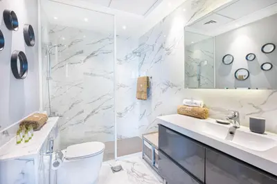 a bathroom with a sink and a toilet and a mirror at Cozy Home at the Heart of Marina on 52nd Floor in Dubai
