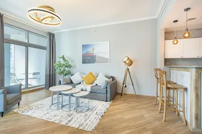 a living room with a couch and a table at Cozy Home at the Heart of Marina on 52nd Floor in Dubai