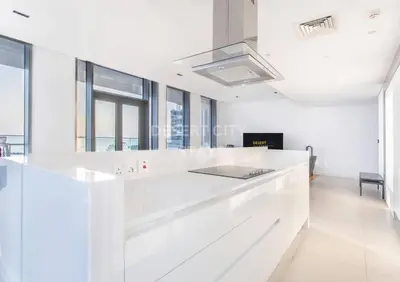 a white kitchen with a large white counter top at Luxurious 2 Bed in Bluewaters, Hosted by Desert City Stays in Dubai