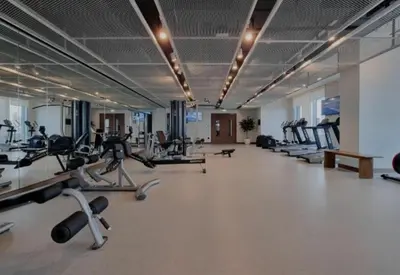 a gym with several treadmills and exercise bikes at White Sage Sun and Sand 1BR at Beach Isle Emaar BeachFront in Dubai