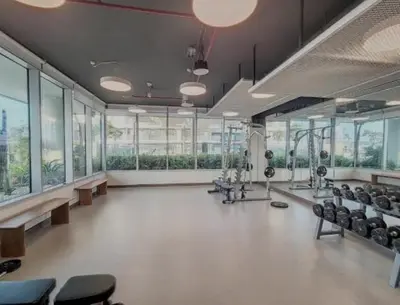 a large room with a gym with chairs and windows at White Sage Sun and Sand 1BR at Beach Isle Emaar BeachFront in Dubai