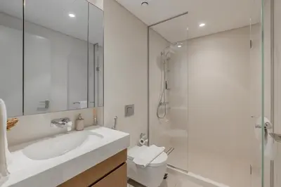 a bathroom with a toilet and a sink and a shower at White Sage Sun and Sand 1BR at Beach Isle Emaar BeachFront in Dubai
