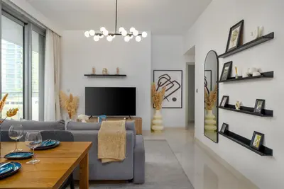 a living room with a couch and a tv at White Sage Sun and Sand 1BR at Beach Isle Emaar BeachFront in Dubai