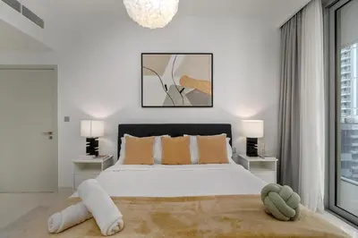 a white bedroom with a large bed and two lamps at White Sage Sun and Sand 1BR at Beach Isle Emaar BeachFront in Dubai