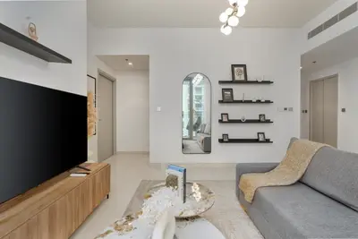 a living room with a couch and a tv at White Sage Sun and Sand 1BR at Beach Isle Emaar BeachFront in Dubai