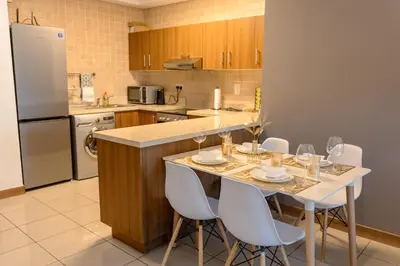 a kitchen with a table with wine glasses on it at Chic Dubai Marina Stay in Dubai