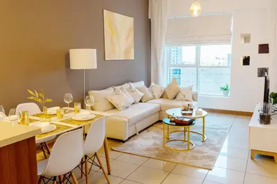 a living room with a white couch and a table at Chic Dubai Marina Stay in Dubai