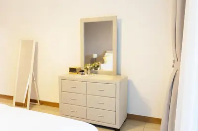a bedroom with a dresser with a mirror on it at Chic Dubai Marina Stay in Dubai