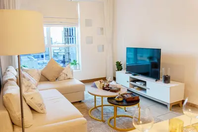 a living room with a couch and a tv at Chic Dubai Marina Stay in Dubai
