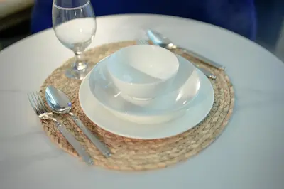 a table with a plate and a cup and a glass at Studio with Terrace Damac Maison Cour Jardin Business Bay in Dubai