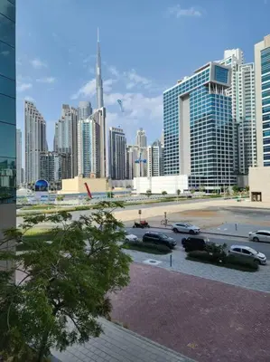 a city skyline with cars parked in a parking lot at Studio with Terrace Damac Maison Cour Jardin Business Bay in Dubai