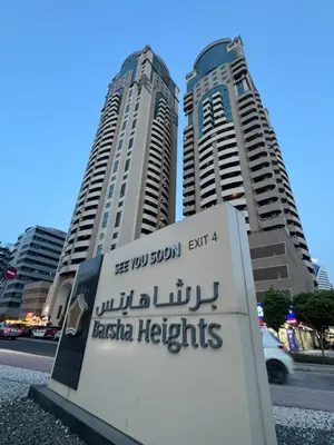 a sign in front of two tall buildings at Loft bed short and long stay in Dubai