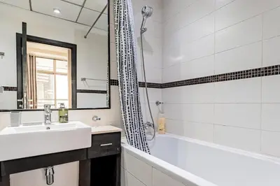 a bathroom with a tub and a sink and a shower at Ultra-Chic 1BR Near Marina & Beach Walk in Dubai